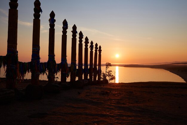 Foto l'alba colorata sulla baia di saraysky del lago baikal ritual shaman poles of serge sull'isola di olkhon