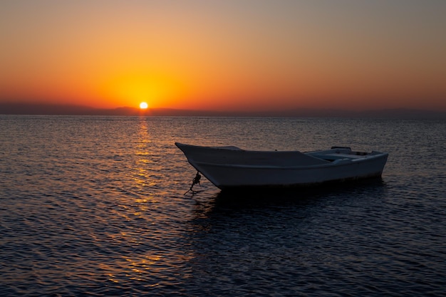 Colorful sunrise seascape with a fisherman boat in the foreground Dahab Sinai Egypt