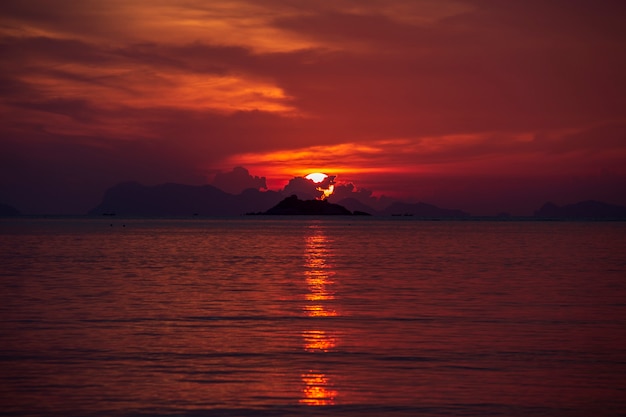 Foto tramonto colorato su acqua di mare calmo.