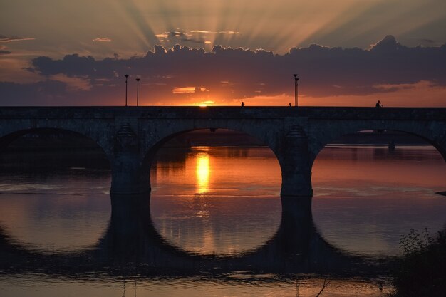 Colorful sunset in the city. The rays of light pass through the clouds.