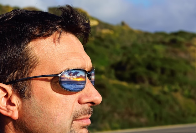 Colorful sunset reflected in sunglasses lens