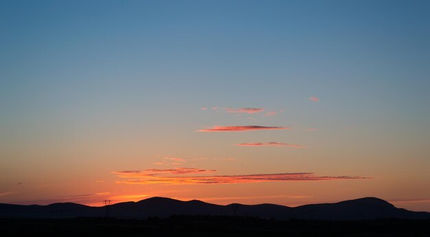 Colorful sunset behind several hills