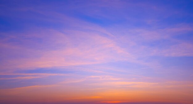 写真 静かな水平空の背景にオレンジ色の太陽光の雲が映っている夕暮れの色鮮やかな空