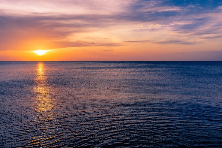 Photo colorful sunset sky over the ocean with dramatic cloud formation