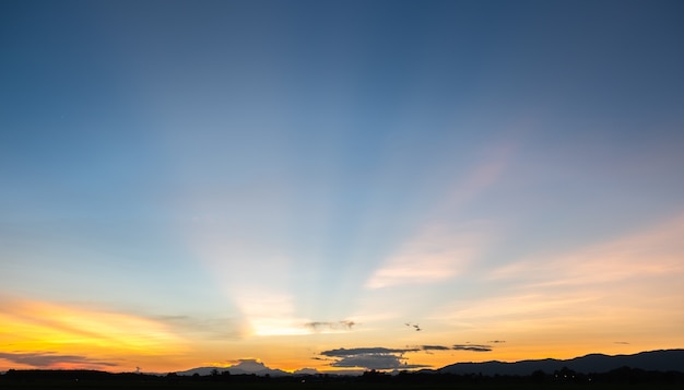 カラフルな夕焼けと日の出と雲。青とオレンジ色の自然。青い空に白い雲がたくさん。今日の天気は晴れ。雲に沈む。空は夕暮れ。