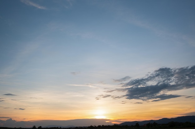 カラフルな夕焼けと日の出と雲。青とオレンジ色の自然。青い空に白い雲がたくさん。今日の天気は晴れ。雲に沈む。空は夕暮れ。