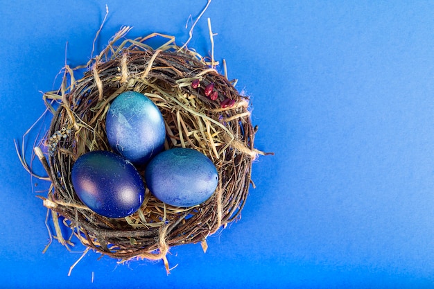 파란색 표면에 부활절 달걀으로 다채로운 표면