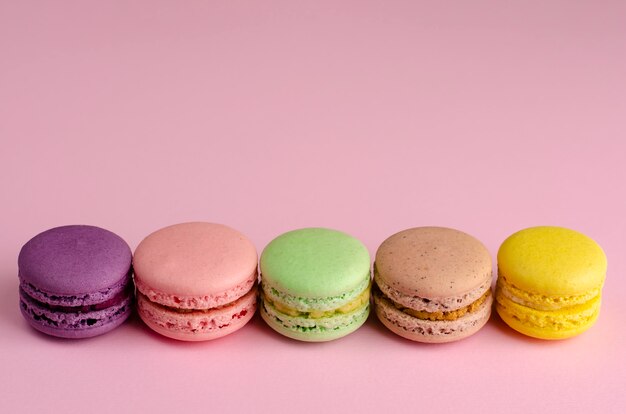 Colorful sweet french dessert macaroon on pastel pink