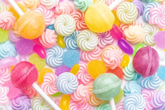 Photo colorful sweet lollipops and candies over white background flat lay top view