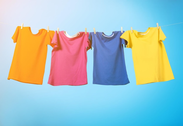 Colorful T-shirts hanging on a rope on a white background