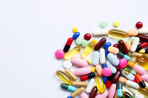 Colorful tablets with capsules and pills on white.