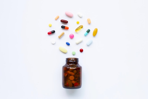 Colorful tablets with capsules and pills on white.