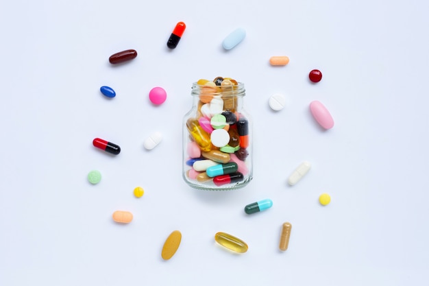 Colorful tablets with capsules and pills on white.