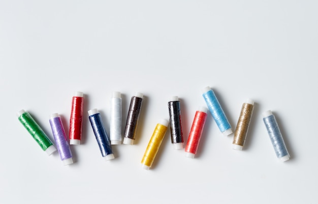 Colorful thread rolls on white background