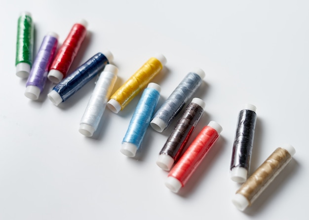 Colorful thread rolls on white background