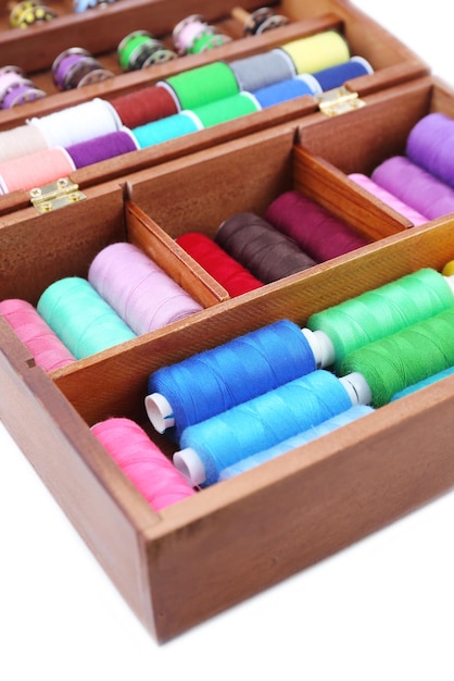 Colorful threads for needlework in wooden box close up