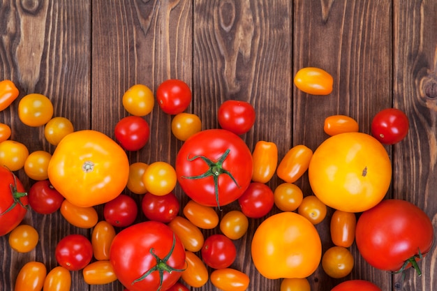 Colorful tomato harvest on wooden table, top view