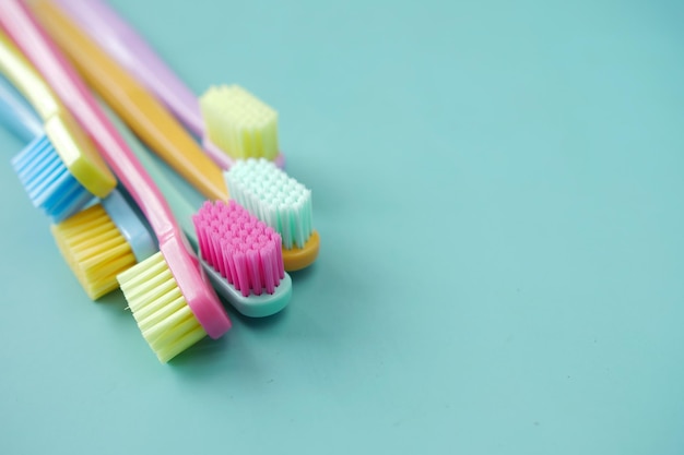 Foto spazzolini da denti colorati su uno sfondo verde chiaro con spazio per la copia