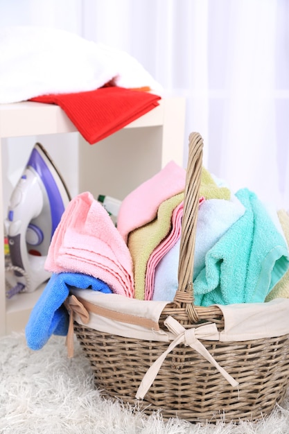 Colorful towels in basket on home interior