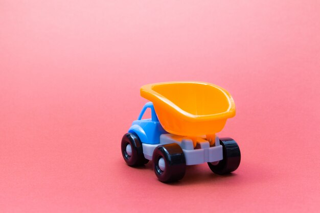 Colorful toy truck on a pink background, rear view