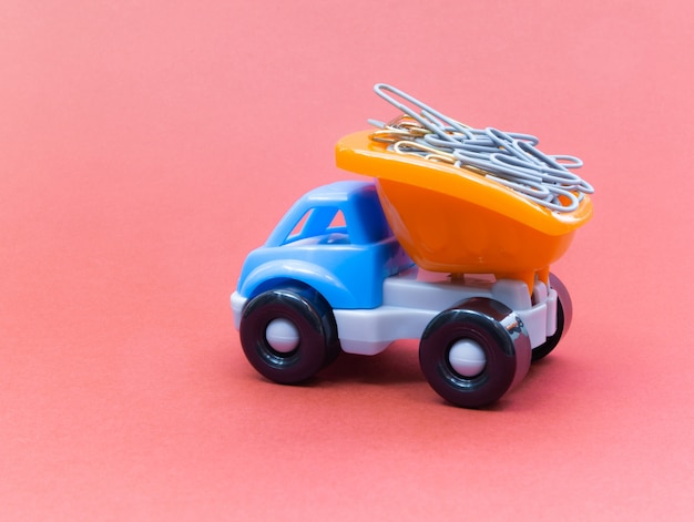 Colorful toy truck on a pink background, stationery in the back