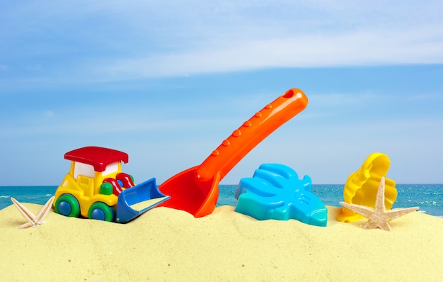 Foto giocattoli colorati per bambini, sandbox contro la sabbia della spiaggia