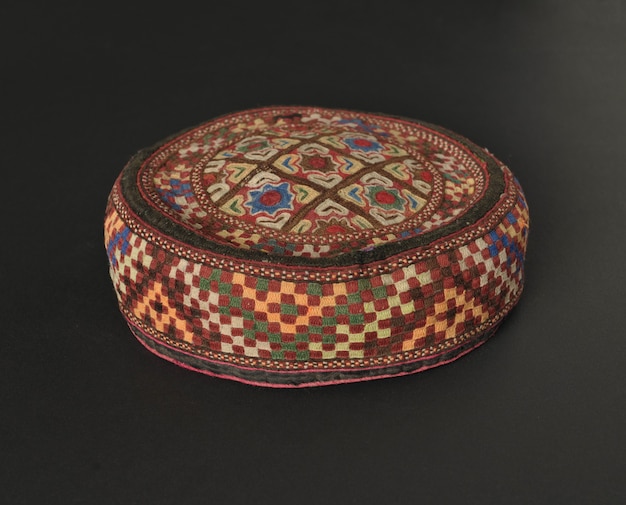 Colorful traditional asian skullcap cap on a dark background