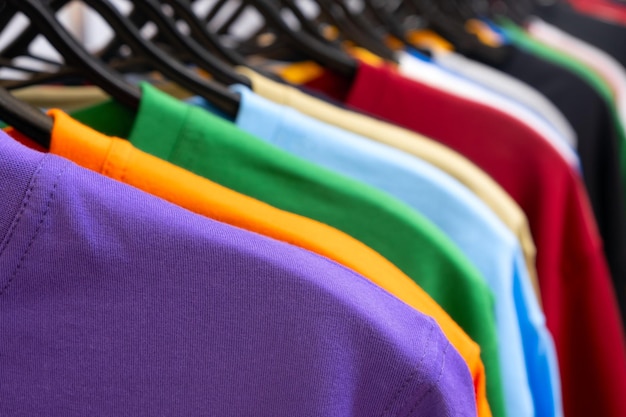 Colorful tshirts on hangers close up view