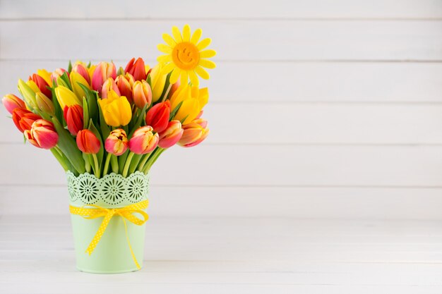 Colorful tulips bouquet on a wooden background