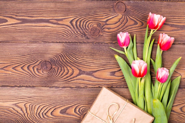 Colorful tulips and gift boxs on wooden table Top view with copy space Flat lay