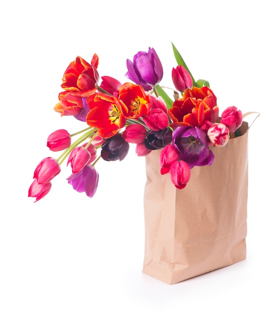 Colorful tulips in a paper bag on a white background.