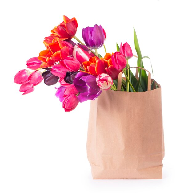 Colorful tulips in a paper bag on a white background.