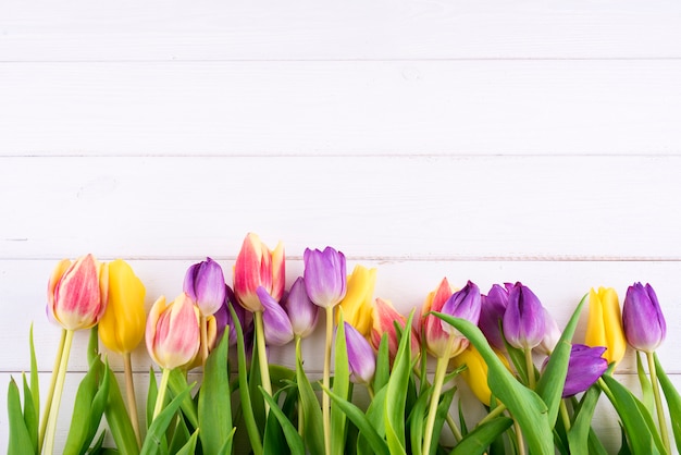 Colorful tulips on a wooden table. Top view with copy space