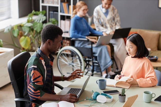 Photo colorful two young professionals collaborating on project at meeting table