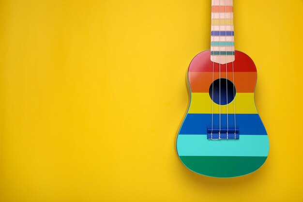 Photo colorful ukulele on yellow background top view with space for text string musical instrument