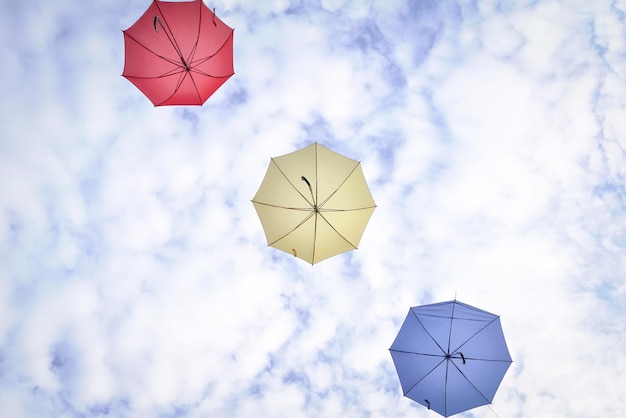 雲と青い空にカラフルな傘