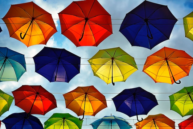 Colorful umbrellas floating above the street on a blue sky