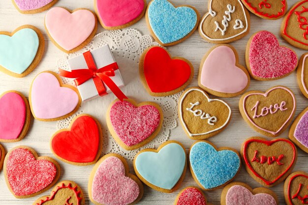 Colorful Valentine heart cookies on wooden table closeup