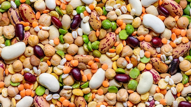 Colorful various dried legumes: lentils bean haricot pea chickpea and other cereals background.