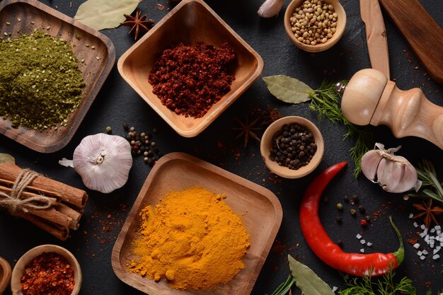 Colorful various herbs and spices for cooking on dark background