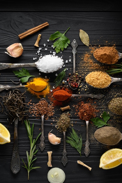 Colorful various herbs and spices for cooking on dark wooden rustic background