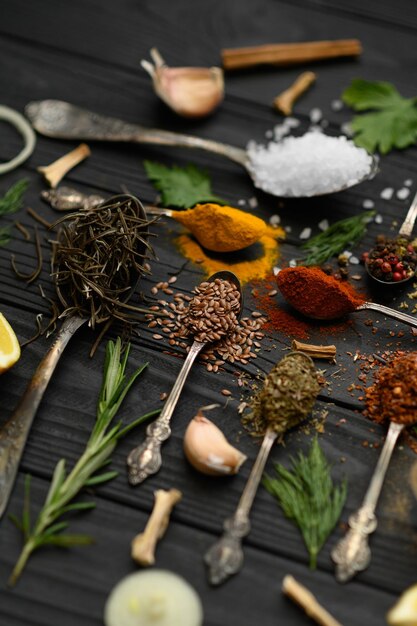 Colorful various herbs and spices for cooking on dark wooden rustic background