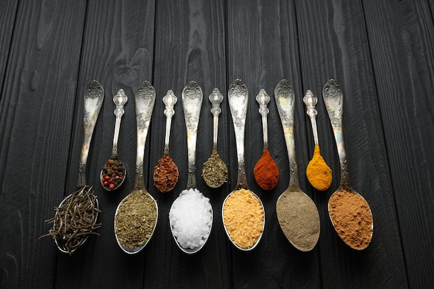 Colorful various herbs and spices for cooking on dark wooden rustic background