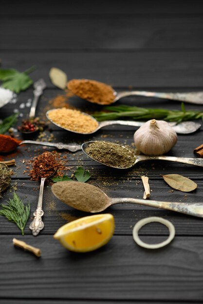 Colorful various herbs and spices for cooking on dark wooden rustic background