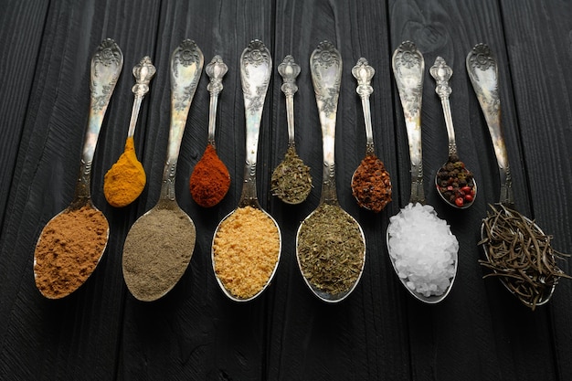 Colorful various herbs and spices for cooking on dark wooden rustic background