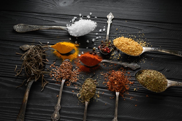 Colorful various herbs and spices for cooking on dark wooden rustic background