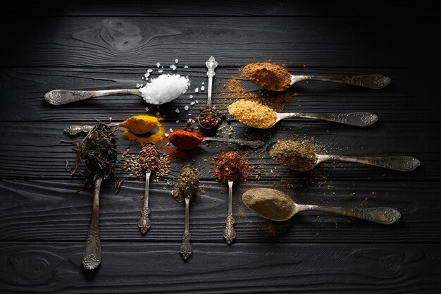 Colorful various herbs and spices for cooking on dark wooden rustic background