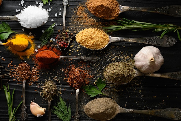 Colorful various herbs and spices for cooking on dark wooden rustic background