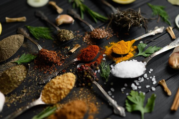 Colorful various herbs and spices for cooking on dark wooden rustic background