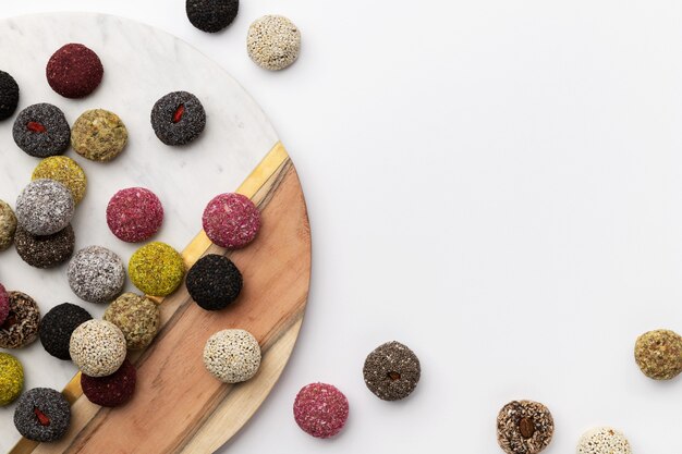 Colorful vegan candies energy balls on a plate on a white table